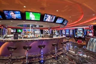 Casino bar featuring monitors for sports events and slot machines | MSC Cruises