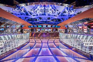 The vibrant casino on MSC Seaside, featuring a bar counter and gaming tables in an inviting space | MSC Cruises