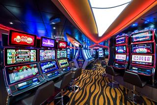 A vibrant casino area on the MSC Seaside featuring numerous slot machines and colourful lighting | MSC Cruises