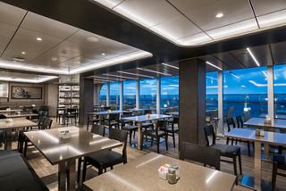 Contemporary restaurant featuring panoramic windows that provide a cozy atmosphere and beautiful views | MSC Cruises