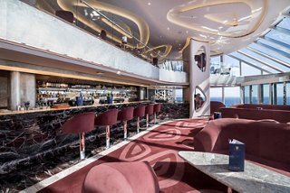 Elegant Top Sail Lounge with a bar counter and panoramic sea views, designed for relaxation in the MSC Yacht Club | MSC Cruises
