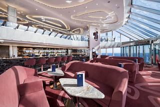 A spacious lounge area in the MSC Yacht Club with plush seating, tables, and panoramic sea views | MSC Cruises