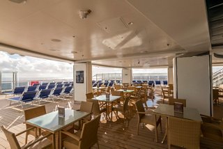 A spacious dining area with wooden tables and chairs, designed for relaxation and enjoyment at sea | MSC Cruises