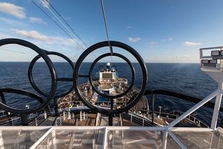 A stunning view of the MSC Seaside deck showcasing the ocean ahead and the ship's zip line area | MSC Cruises