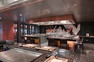 A vibrant dining area featuring an open kitchen and Teppanyaki grill at the Asian Market Kitchen | MSC Cruises