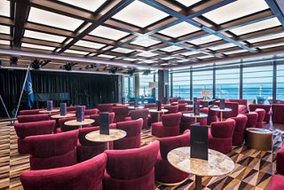 A stylish seating area in the Seaview Lounge, featuring plush chairs and large windows offering stunning sea views | MSC Cruises