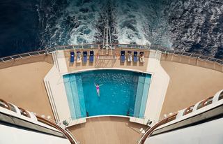 Luftaufnahme eines ruhigen Poolbereichs auf der MSC Seaside, umgeben von entspannenden Oceanwellen und Gästen, die den Raum genießen | MSC Cruises
