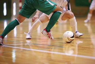Players engaging in a fast-paced soccer game on a wooden court, showcasing teamwork and excitement | MSC Cruises