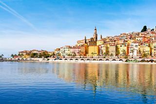Une vue pittoresque des bâtiments colorés de Menton le long de la côte, se reflétant dans les eaux calmes de la Méditerranée | MSC Croisières