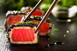 Sushi rolls garnished with vibrant ingredients, ready to be enjoyed with chopsticks | MSC Cruises