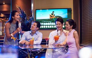 A joyful couple enjoys cocktails while participating in karaoke entertainment on board MSC Splendida | MSC Cruises