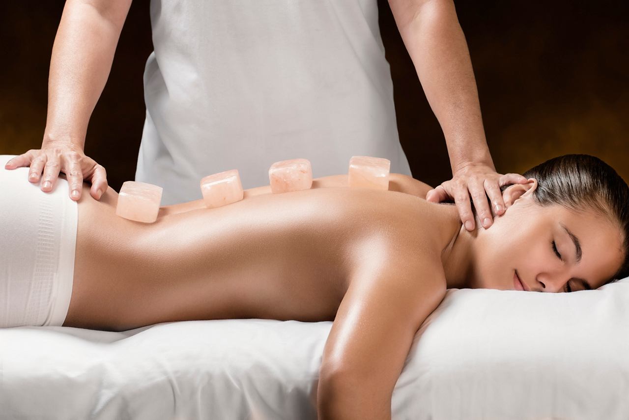 A woman receives a soothing back massage in the serene MSC Aurea Spa environment | MSC Cruises