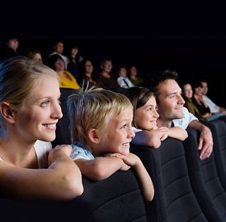 Eine Familie genießt gemeinsam eine aufregende Show im Theater und schafft fröhliche Erinnerungen an Bord eines Kreuzfahrtschiffs | MSC Cruises