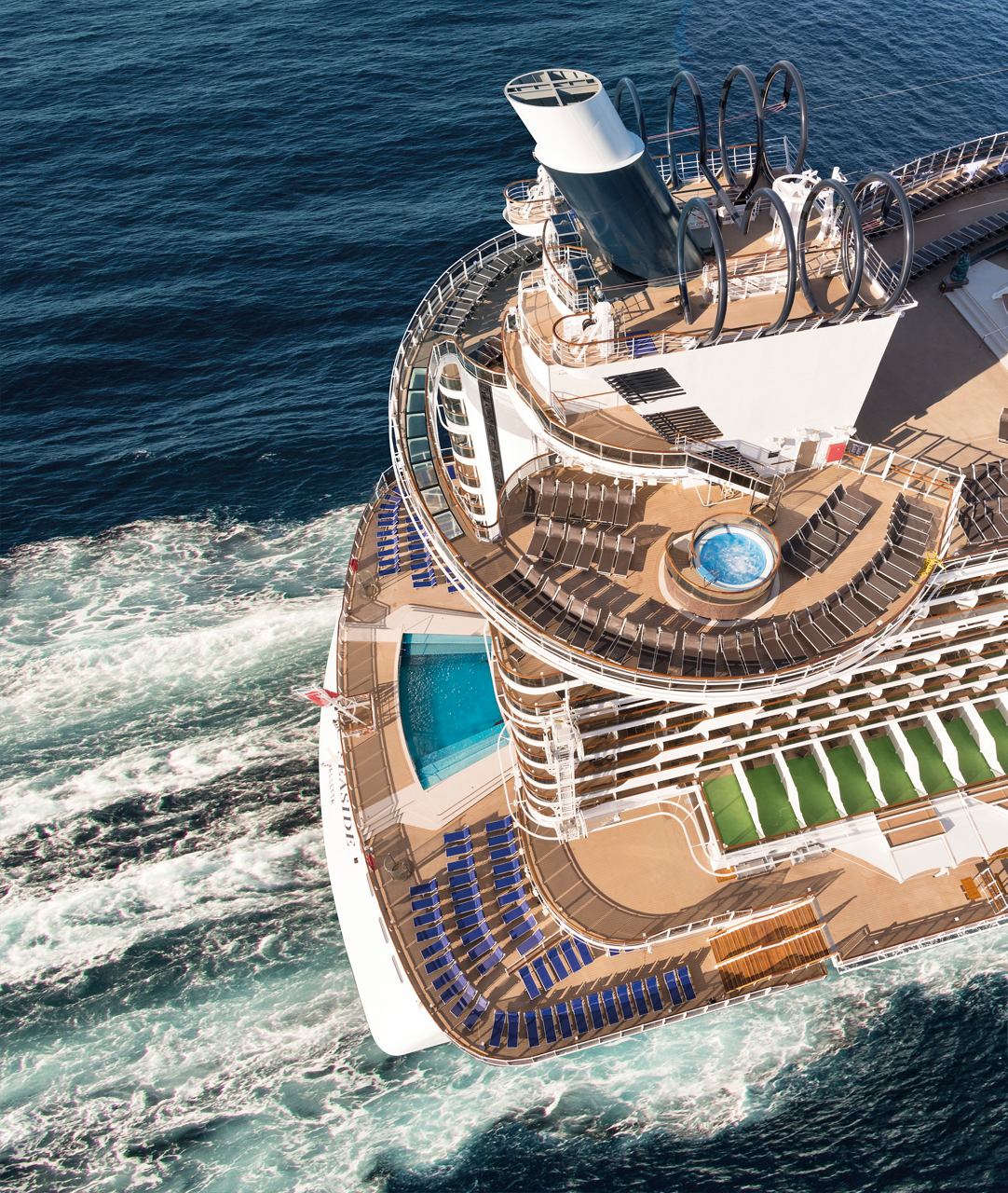An aerial view of the MSC Seaside showcasing its pool area and wake trailing behind in the open sea | MSC Cruises