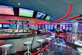 A vibrant bar area within the Platinum Casino, featuring sleek seating and multiple screens for entertainment | MSC Cruises