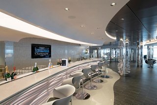 A stylish bar area with a sleek counter, stools, and elegant decor inviting guests to relax and enjoy | MSC Cruises