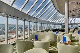 A luxurious lounge area in the MSC Yacht Club with panoramic windows and elegant seating for relaxation | MSC Cruises
