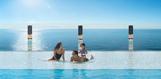 Una familia disfruta de un día soleado junto a la piscina con vista al mar | MSC Cruceros