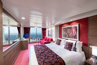 A luxurious suite featuring a double bed, balcony, sofa, and modern amenities for a memorable cruising experience | MSC Cruises