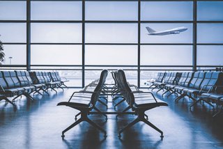 Ein geräumiger Wartebereich am Flughafen mit großen Fenstern, ideal zum Entspannen vor Ihrem Flug | MSC Cruises