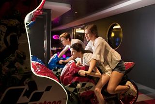 Teenagers are engaged in an exciting virtual racing game in the arcade area aboard MSC Meraviglia | MSC Cruises