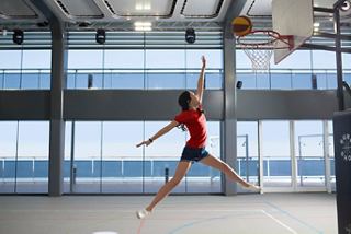 Un jeune athlète saute pour jouer au basketball à bord d'un navire de croisière, rayonnant d'énergie et de joie | MSC Croisières