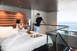 A couple enjoys breakfast in a stylish Duplex Suite with a sea view on MSC Meraviglia | MSC Cruises