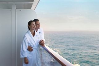 A couple in bathrobes enjoys a relaxed moment together on their balcony overlooking the serene sea | MSC Cruises