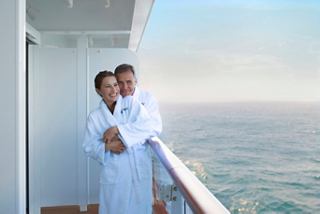 Un couple en peignoirs s'étreint sur leur balcon, profitant d'un moment paisible en mer | MSC Croisières