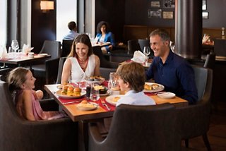 Una familia disfruta de una deliciosa comida en un restaurante a bordo del MSC Meraviglia | MSC Cruceros