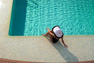 Una mujer se relaja al borde de la piscina en el MSC Yacht Club del MSC Seaview | MSC Cruceros