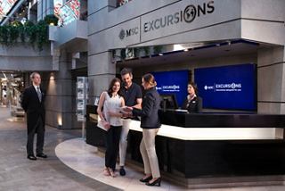 Gäste erhalten Unterstützung vom freundlichen Personal an der MSC Yacht Club Rezeption auf der MSC Meraviglia | MSC Cruises