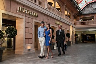 A couple enjoys a shopping experience with attentive staff at the Galleria Meraviglia on MSC Meraviglia | MSC Croisières