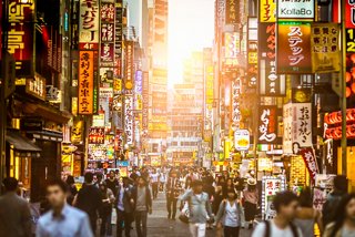 Una strada vivace a Shinjuku, Tokyo, illuminata dal tramonto e da insegne vivaci, piena di persone che esplorano l'area | MSC Crociere