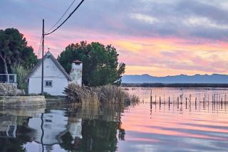 Un tramonto mozzafiato sul lago Albufera, con case tradizionali in primo piano | MSC Crociere