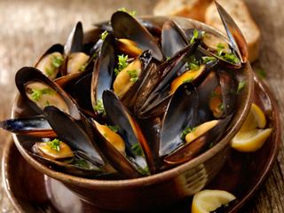 Un délicieux bol de moules aux herbes et citron, accompagné de pain frais | MSC Croisières