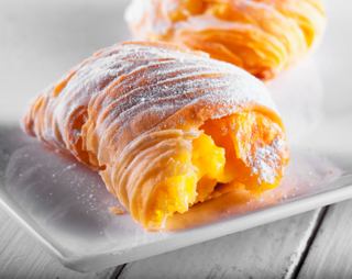 Delight in a traditional Italian sfogliatella pastry, showcasing its delicate layers and rich filling | MSC Cruises