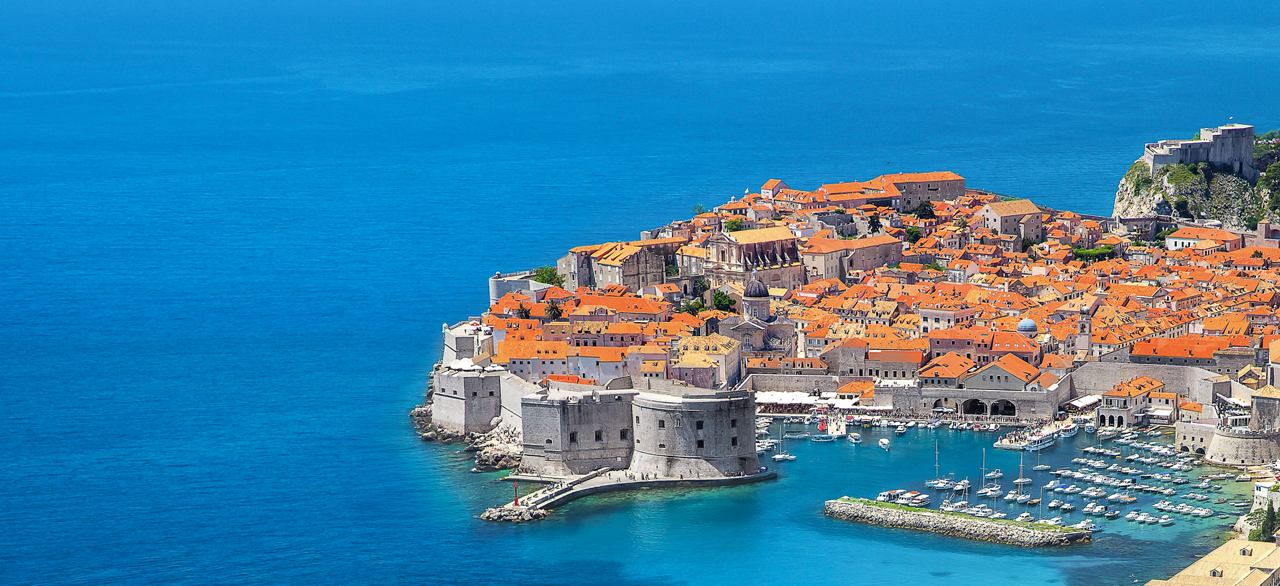 Una vista impresionante de la costa de Dubrovnik con su arquitectura histórica y techos vibrantes contra el mar azul | MSC Cruceros