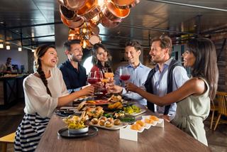 Amigos disfrutan de un brindis con bebidas en Hola! Tapas Bar en MSC Bellissima | MSC Cruceros