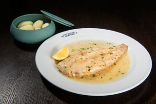 Un lenguado de Dover bellamente presentado con mantequilla y hierbas, que muestra la excelencia culinaria a bordo del MSC Bellissima | MSC Cruceros