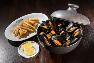 Une délicieuse portion de moules marinières avec des frites et du citron, invitant à une expérience culinaire agréable | MSC Croisières