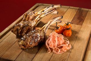 A beautifully arranged platter featuring a rack of lamb and colourful tomatoes | MSC Cruises