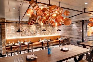 A welcoming dining area featuring elegant wooden furniture and warm lighting at Hola! Tapas Bar | MSC Cruises