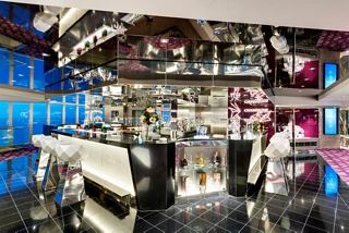 A stylish bar area featuring a sleek design with a bar counter and champagne bottles ready to serve guests | MSC Cruises