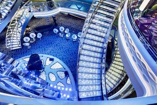 A stunning top view of the Infinity Atrium on MSC Grandiosa, showcasing elegant stairs and a spacious sitting area | MSC Cruises