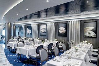 Elegant dining area with neatly arranged tables and artwork, inviting guests to enjoy a memorable meal | MSC Cruises
