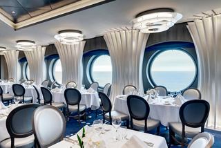 Elegant dining area with circular portholes and stylish seating on MSC Grandiosa | MSC Cruises