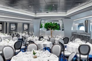 Elegante área de comedor en el restaurante principal, con mesas bellamente dispuestas y vegetación exuberante | MSC Cruceros