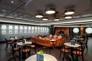 Un elegante interior de restaurante con un acogedor área de estar, mesas y decoración artística para una experiencia culinaria encantadora | MSC Cruceros