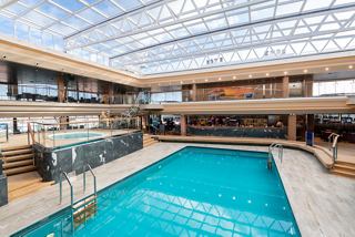 A bright and inviting indoor pool area with a sliding roof and whirlpool bath, perfect for relaxation | MSC Cruises